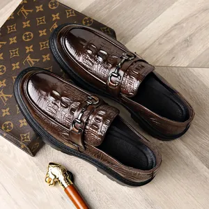Dark brown crocodile embossed leather loafers with elegant metal horsebit buckle detail