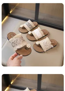 Primer plano de sandalias planas tejidas bohemias con correas de flecos y flores