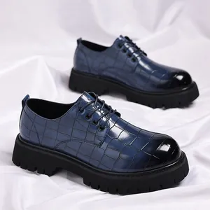 Vista dettagliata di scarpe stringate blu da uomo con motivo coccodrillo e suola alta