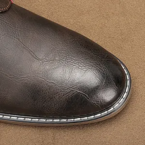 Close-up of vintage brown leather men's shoe showing texture and white stitching details