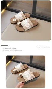 Detalle de la textura tejida con flecos y camelia en las sandalias de dedo para mujer