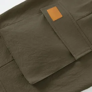 Macro view of a durable cargo pocket and leather patch on olive tactical shorts