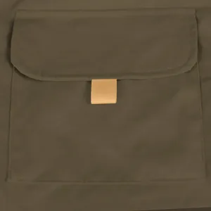 Close-up view of tactical cargo shorts pocket featuring durable flap and beige pull tab