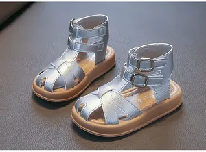 Nahaufnahme von silbernen geflochtenen Römersandalen für Mädchen mit stylischen Schnallen
