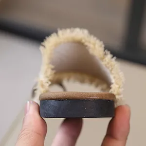 Vista posterior detallada de sandalias planas tejidas con flecos para mujer para la playa