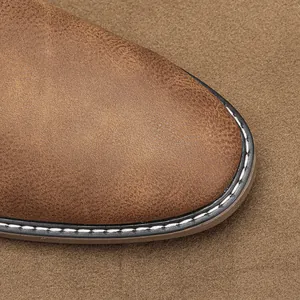 Detailed macro view of vintage brown leather casual shoe toe with white stitching