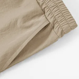 Close-up of elastic waistband and side pocket detail on khaki cargo shorts