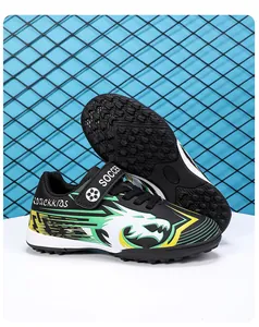 Chaussures de football pour enfants avec motifs de dragon verts et sangles velcro.