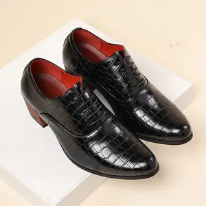 Dettaglio scarpe rialzate da uomo nere con motivo coccodrillo e tacco alto spesso.