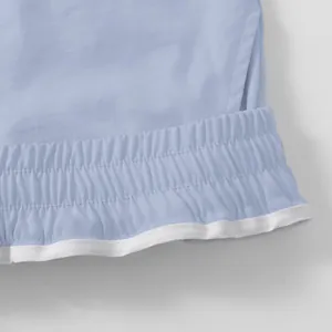 Detailed macro shot of elastic waistband and stitching on blue men's cargo shorts.