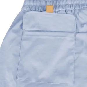 Detailed close-up showing the flap pocket and elastic waistband of men's blue cargo shorts