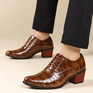 Dettaglio scarpe eleganti da uomo marroni con trama coccodrillo e tacco rosso spesso