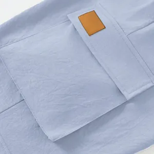 Detailed macro view of a light blue cargo pocket on loose tactical men's work shorts