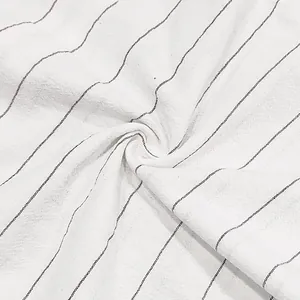 Close-up macro view of breathable white linen fabric featuring thin black vertical stripes.