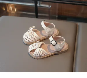 Close-up detail of the woven breathable upper and bow on girls' beige summer sandals