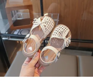 Close-up detail of cream woven breathable toddler girl's summer sandals with bow