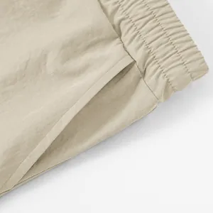 Detailed macro shot of khaki tactical shorts featuring elastic waistband and pocket