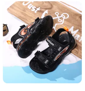 Vista de detalle de sandalias deportivas negras para niño con detalles naranjas