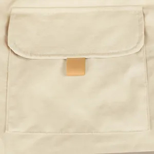 Macro detail shot showing the beige cargo pocket and stitching of men's tactical shorts