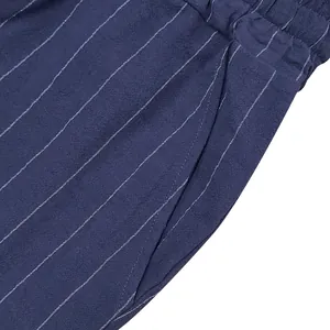 Detailed close-up of blue vertical striped linen shorts showing pocket and fabric texture.