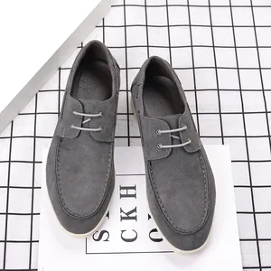 Détail de mocassins en daim gris avec semelles blanches et lacets décoratifs élégants