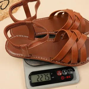 Detailed view of lightweight brown flat gladiator sandals weighing 227.5g on a scale