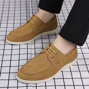Vue rapprochée de la texture en daim des mocassins marron pour hommes sur sol damier