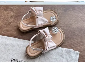 Detail view of pink girls' princess sandals with large bow and rhinestone flower decoration