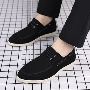 Detailed view of men's black suede casual loafers featuring classic laces and white flat soles