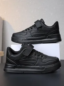 Durable all-black boys' sneakers with hook-and-loop strap and lace-up design