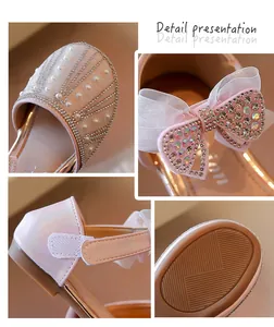 Detailed view of rhinestone bow and pearl decorations on pink girls shoes