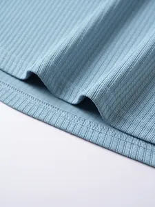 Dettaglio macro del tessuto a costine blu e delle cuciture di una t-shirt da uomo a maniche corte.