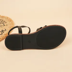 Close-up detail of the durable non-slip sole on black summer flat Roman beach sandals.