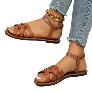 Stylish brown Roman flat sandals for women featuring elegant crossover straps and ankle support