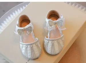 Detail view of white girls princess shoes with sparkling rhinestones and pearls