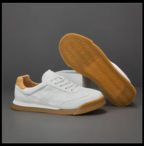 Detail view of white breathable leather German army trainer sneakers with rubber soles.