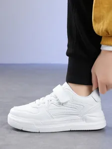 Side view detail of white children's sports sneaker showing velcro strap and stitch pattern.