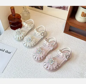 Detailansicht von Mädchensandalen mit glitzernder Strassblume und Perlen