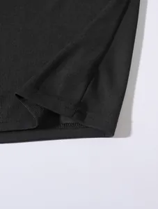 Nahaufnahme des hochwertigen Strickgewebes und der feinen Saumnaht eines schwarzen Poloshirts