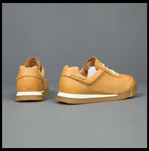 Detail view showing the back and side of mustard yellow genuine leather GAT sneakers