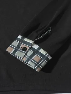 Detailansicht der Manschette mit Karomuster und schwarzem Knopf an einem Herren-Poloshirt