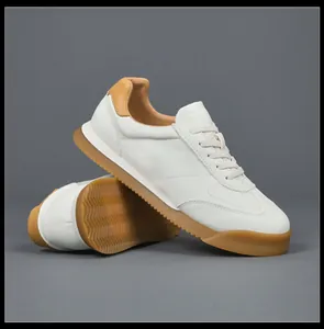 Close-up of white leather sneakers with classic gum rubber soles and non-slip texture