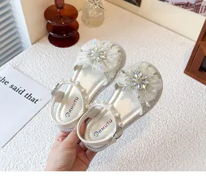 Detail der glitzernden Kristallblume und des Perlenriemens an der weißen Sandale