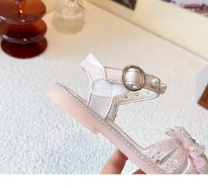 Nahaufnahme der pinken Mädchensandale mit Glitzer-Finish und eleganten Perlen-Details