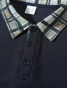 Nahaufnahme eines dunkelblauen Poloshirts mit Karokragen und feiner Stricktextur.