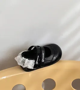Gros plan d'une chaussure noire pour fille avec dentelle blanche et bride élégante