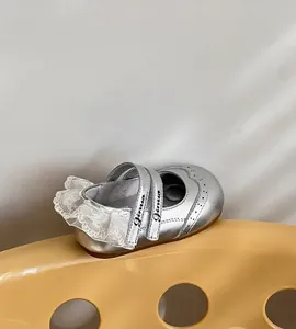 Gros plan de chaussures de princesse argentées pour filles avec dentelle et détails brogue