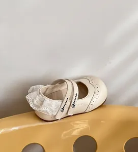 Détail des chaussures Mary Jane pour tout-petits avec bordure en dentelle blanche.