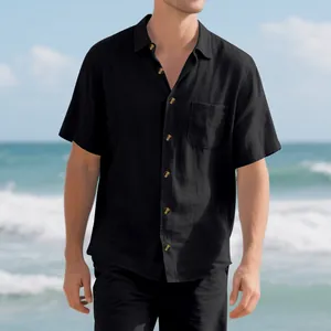 Detail view of a men's black short-sleeve casual button-up shirt in a beach setting