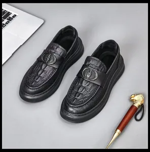 Detailed view of black leather loafers with premium crocodile embossing and stylish metallic buckle.